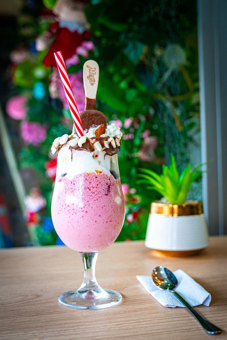 Batido rosa Panichini frente al muro floral del salón